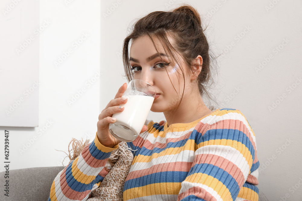 Young woman drinking milk at home, closeup Young woman drinking milk at home, closeup