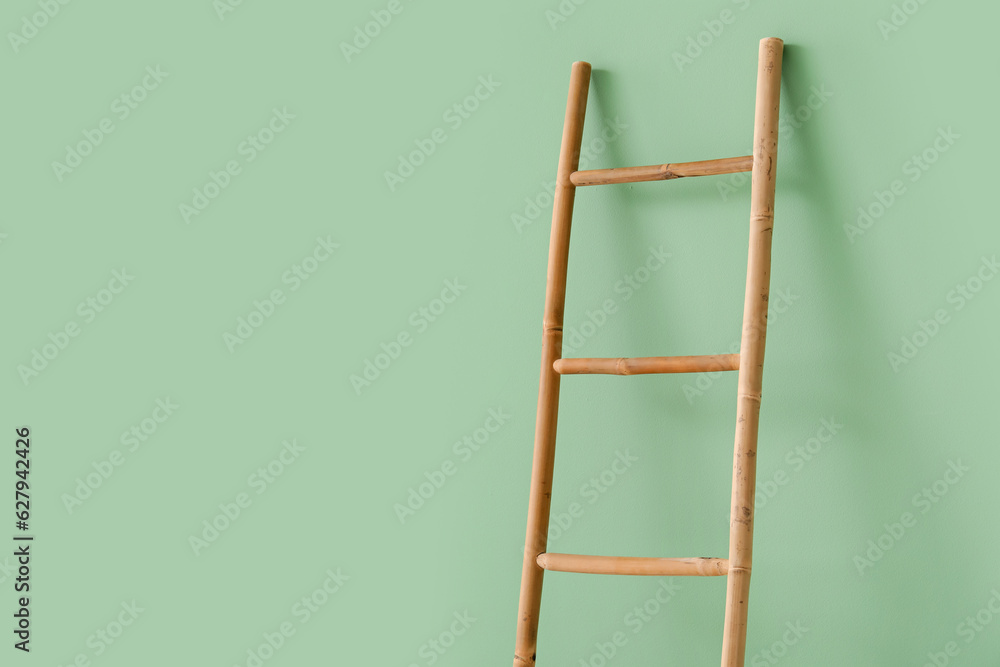 Wooden ladder near green wall in room