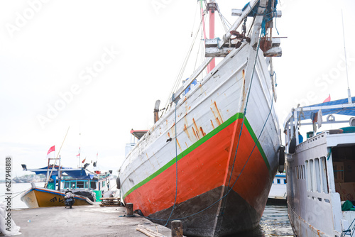 Several wooden boats and cargo ships moored at the traditional port while waiting for loading and unloading