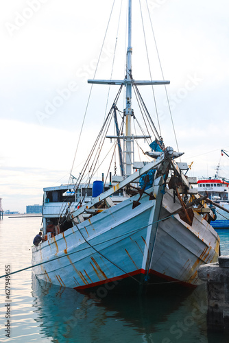 Several wooden boats and cargo ships moored at the traditional port while waiting for loading and unloading