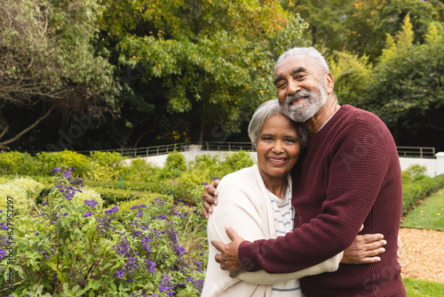 Tableau sur toile Portrait of happy senior biracial couple embracing in garden at home, copy space