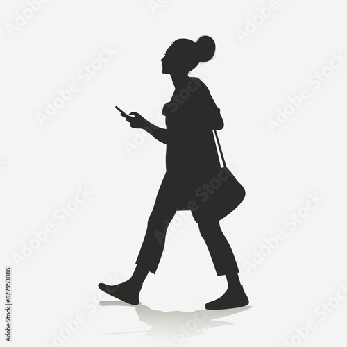 Silhouette of a woman walking while holding a cell phone