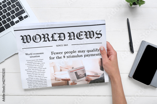 Woman reading newspaper at ...
