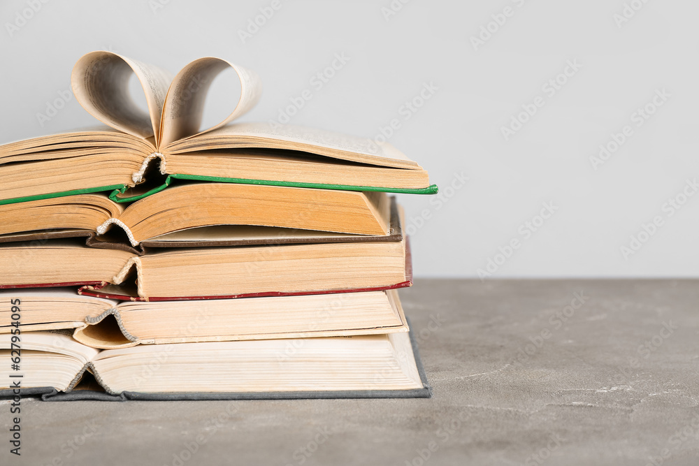 Stack of open books on grey grunge table Stack of open books on grey grunge table