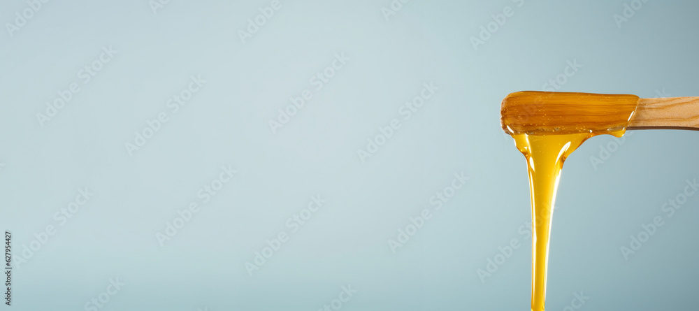 Liquid sugar wax on spatula, flowing, dripping Liquid sugar wax on spatula, flowing, dripping