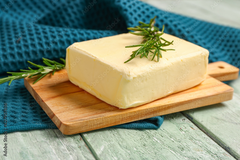 Board with fresh butter and rosemary on green wooden background Board with fresh butter and rosemary on green wooden background