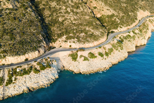 Aerial view of winding coastal highway with mountains on one side and Mediterranean sea