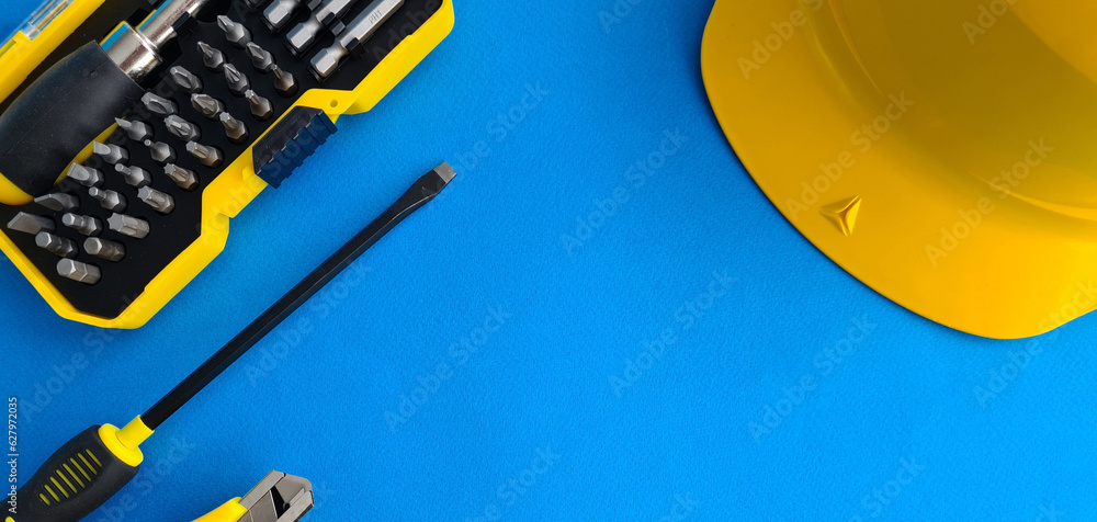 Construction tools, hard hat on blue background with copy space