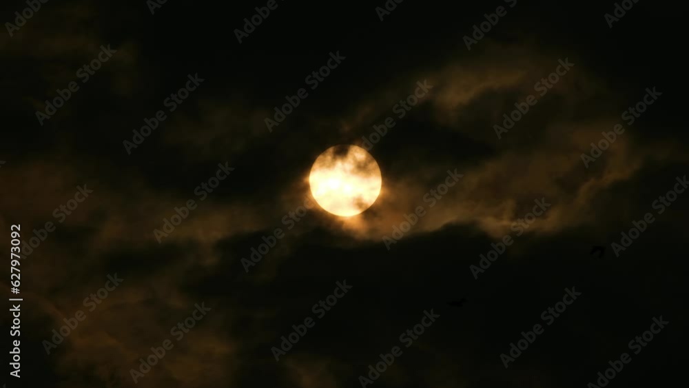 Yellow Moon or Sun seen through dark Clouds with Birds Quickly Flying in Front (UHD) Yellow Moon or Sun seen through dark Clouds with Birds Quickly Flying in Front (UHD)