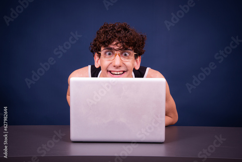 Funny silly guy chatting online and watching adult movies. photo