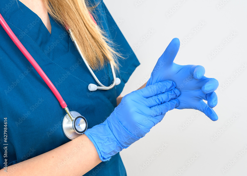 Lekarka zakładająca rękawiczki chirurgiczne - obrazy, fototapety, plakaty 