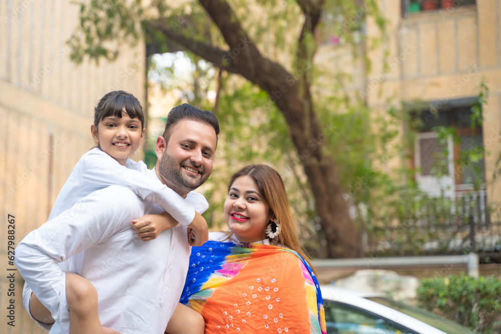 Fototapeta premium indian family standing outdoor and giving happy expression.