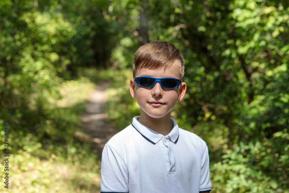 Portrait of a boy in sunglasses in nature, looking at the camera. Portrait of a boy in sunglasses in nature, looking at the camera.