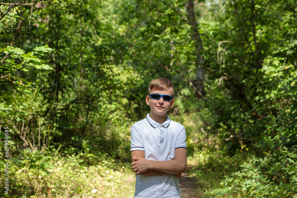 Portrait of a boy in sunglasses in nature, looking at the camera. Portrait of a boy in sunglasses in nature, looking at the camera.