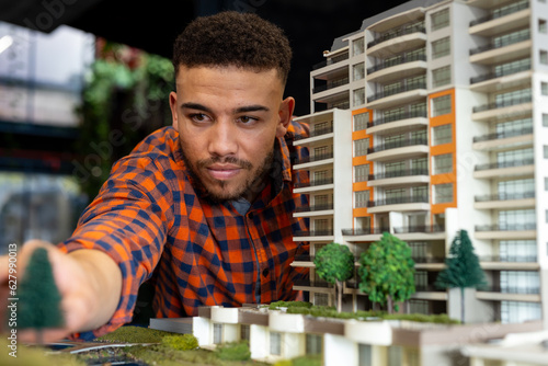Biracial male architect working on a building model at office photo