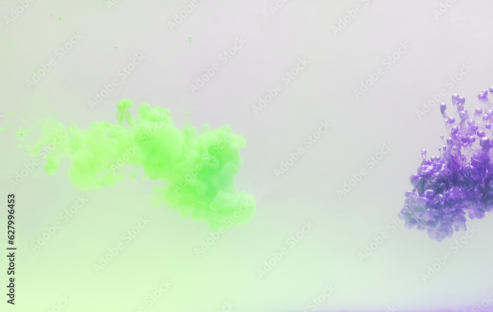 Fototapeta premium Close up of green and purple ink in water with copy space on white background