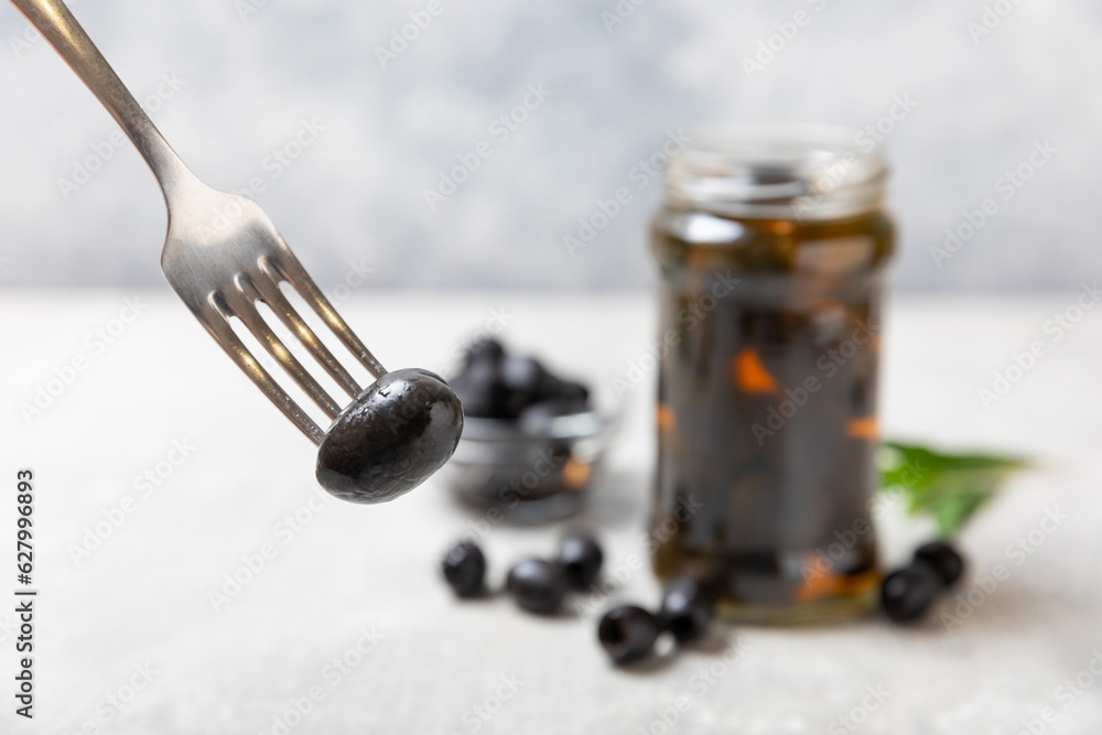 Delicious black olives. Pickled olives in glass jar. On a wooden background.Tasty olives. Close-up. Vegan.Place for text. copy space.