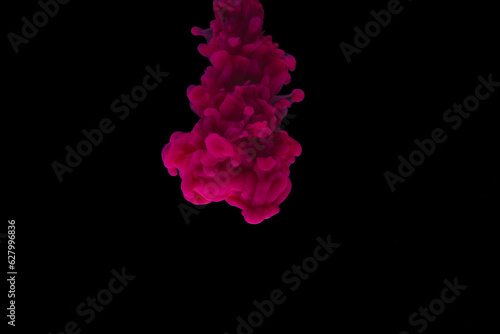 Close up of bright pink ink in water with copy space on black background