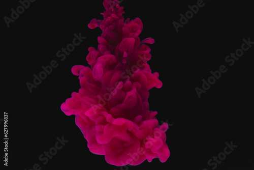 Close up of bright pink ink in water with copy space on black background