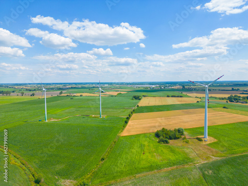 Aerial view of powerful Wind turbine farm for energy production on beautiful cloudy sky at highland. Wind power turbines generating clean renewable energy for sustainable development.