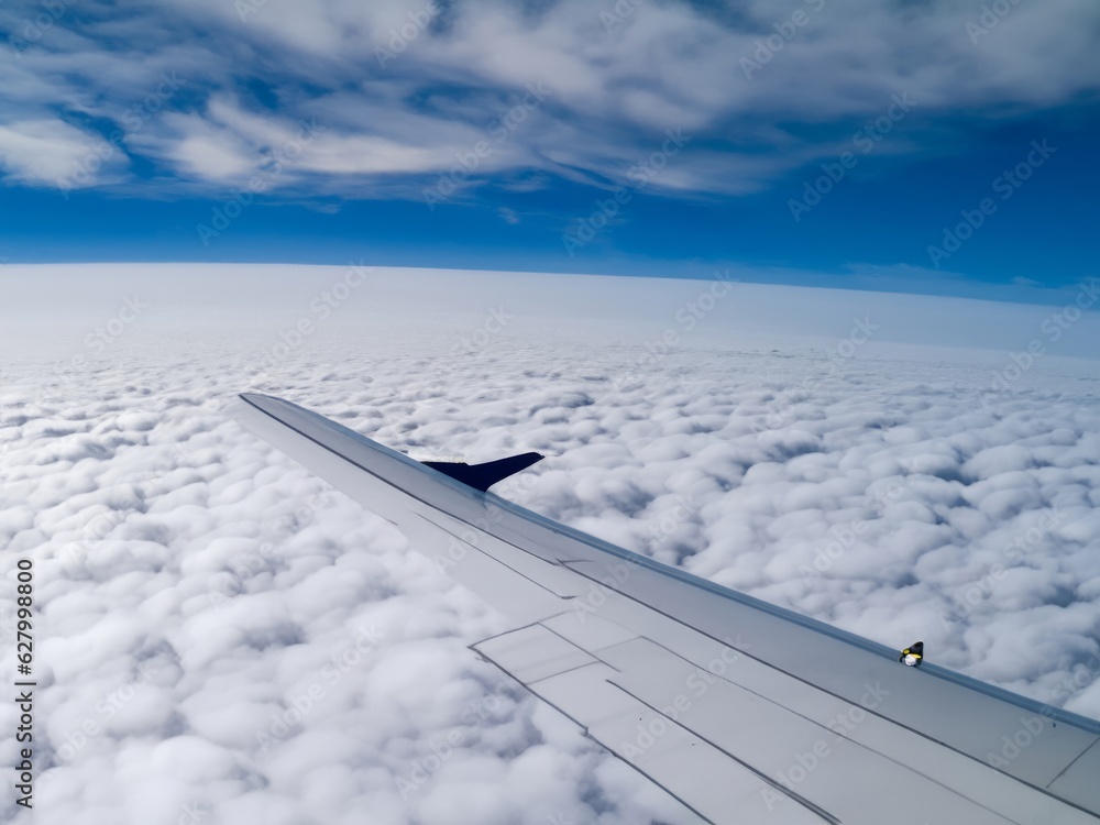 Fototapeta premium airplane over the clouds one wing in picture