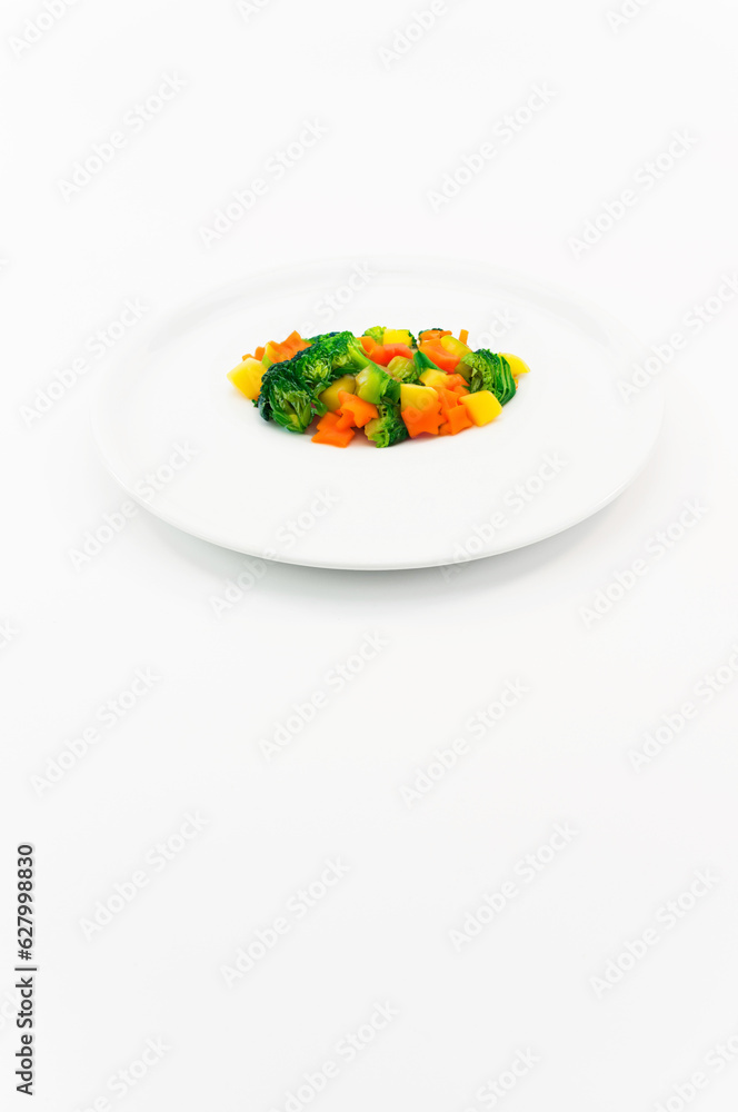 immagine primo piano di piatto bianco con porzione di verdure cotte al vapore, contorno vegetariano su superficie bianca immagine primo piano di piatto bianco con porzione di verdure cotte al vapore, contorno vegetariano su superficie bianca