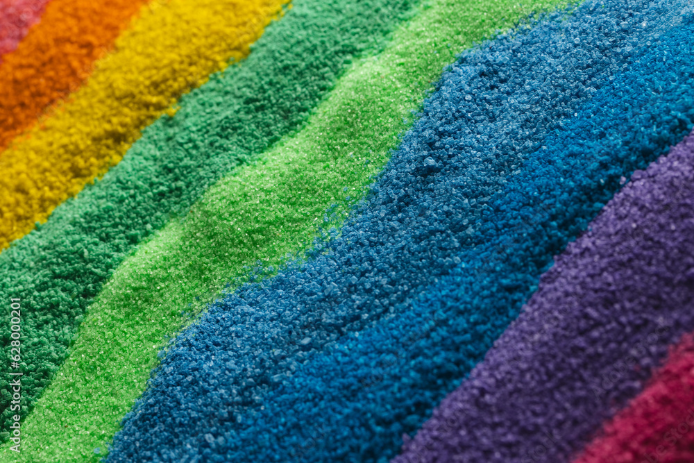 Close up of stripes of rainbow coloured sand and copy space background