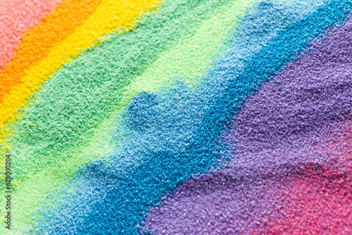 Close up of stripes of rainbow coloured sand and copy space background