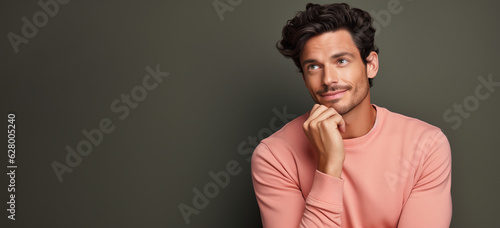 handsome young man thinking or having an idea isolated on flat color background. Business concept.