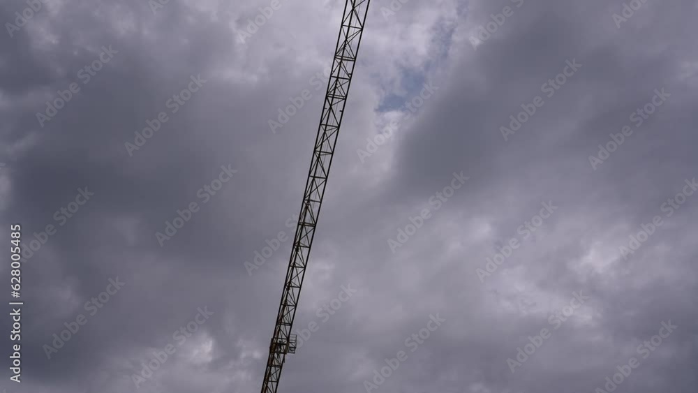 4K time lapse video on a construction site with cranes working and moving against storm clouds in background. Summer storm in construction industry. 4K time lapse video on a construction site with cranes working and moving against storm clouds in background. Summer storm in construction industry.