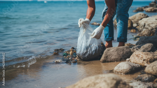 Man in gloves pick up plastic bags that pollute sea. Problem of spilled rubbish trash garbage on the beach sand caused by man - made pollution and environmental, campaign to clean volunteer in concept