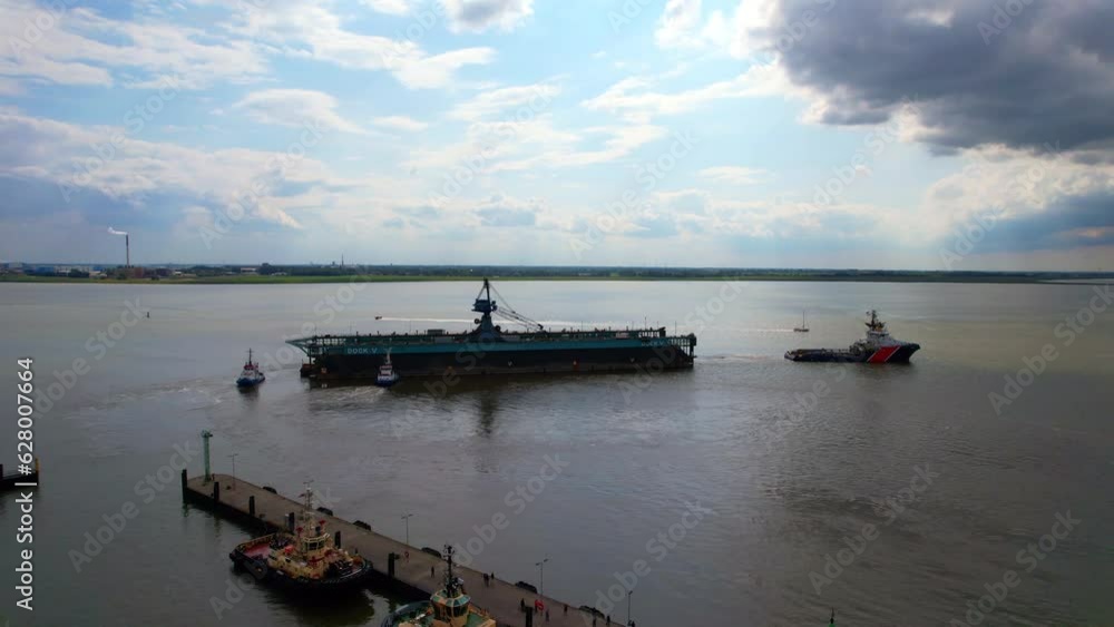 Bremerhaven - ship dock is pulled by the ocean tug - an aerial view with the drone over the river Weser Bremerhaven - ship dock is pulled by the ocean tug - an aerial view with the drone over the river Weser