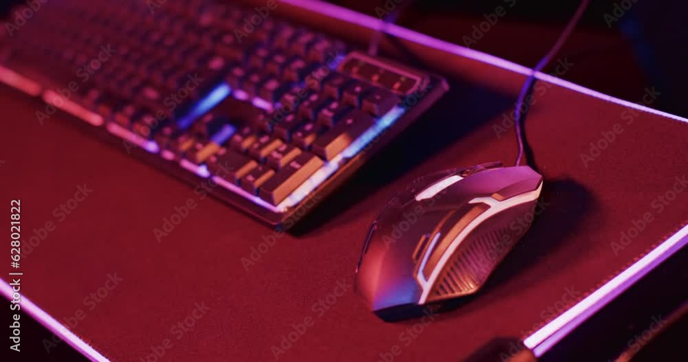 Video of gaming computer and gaming equipment on desk with copy space on neon background Video of gaming computer and gaming equipment on desk with copy space on neon background