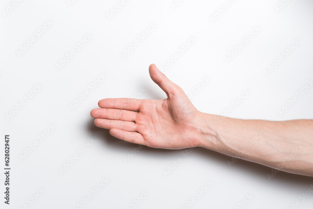 Close-up of a man's hand. He stretches out his hand for a handshake gesture on a white background.