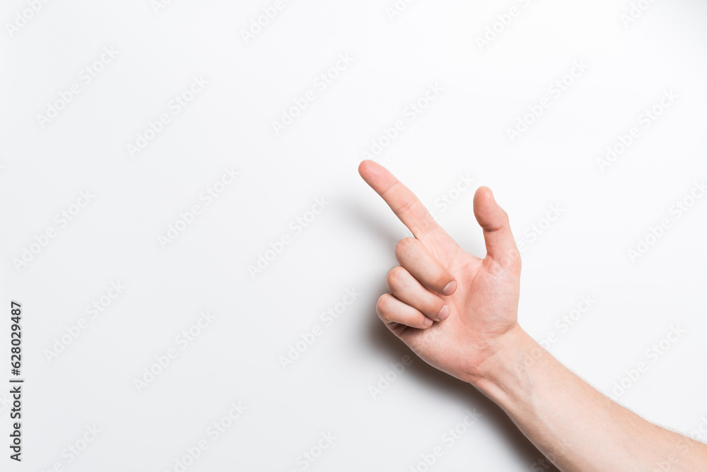 A close-up of a man's hand points with his index finger at a copy space for advertising on a white background. A close-up of a man's hand points with his index finger at a copy space for advertising on a white background.