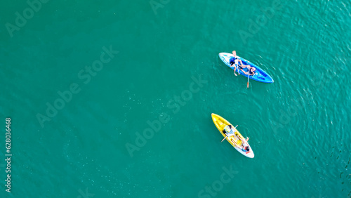Aerial view of canoe boats in mountain river with turquoise water with rock cliffs. People kayaking, canoeing, and swimming in Kedung Jati Parang, Selopamioro, Imogiri, Bantul, Yogyakarta. photo