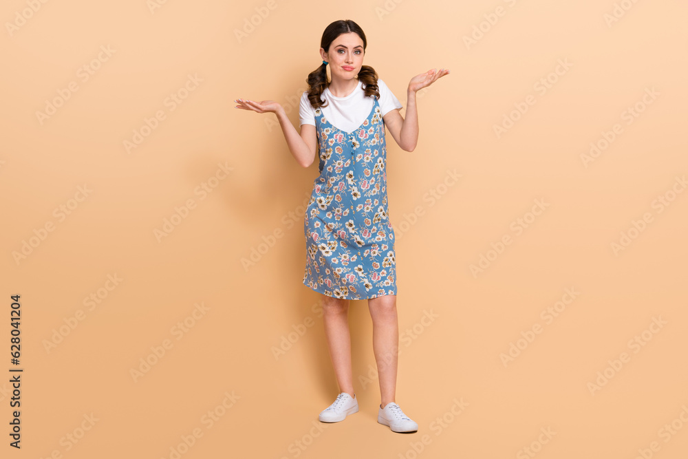 Full body size photo of young girl shrug shoulders dilemma no idea dont you buy summer season clothes isolated on beige color background Full body size photo of young girl shrug shoulders dilemma no idea dont you buy summer season clothes isolated on beige color background