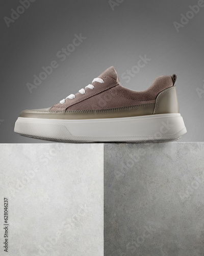 Modern street shoes stand stone on stone against a gray background