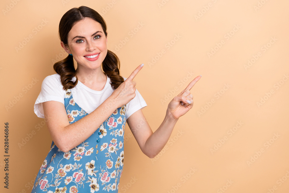 Portrait of optimistic adorable woman tails hairstyle dressed white shirt indicating at offer empty space isolated on beige color background Portrait of optimistic adorable woman tails hairstyle dressed white shirt indicating at offer empty space isolated on beige color background