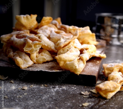 Angel wings covered in powdered sugar. Polish faworki, sweet delicacy, dessert.  photo