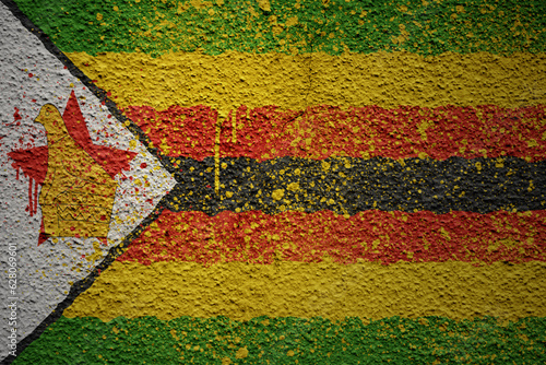 painted big national flag of zimbabwe on a massive old cracked wall