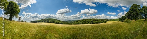 Valokuva panorama hill country side with forest and meadow with hunters high seat