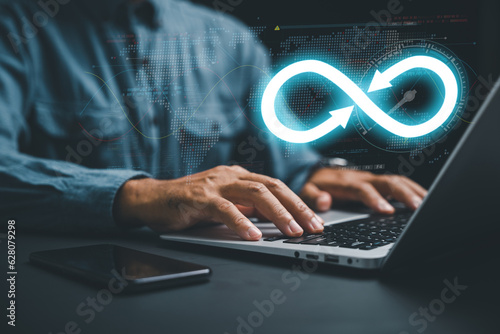 DevOps engineer in agile environment. infinity icon on computer, coder typing. Integration of software development IT operations. concept of continuous integration. technology infinity data