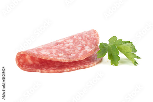 One sliced of delicious smoked sausage and parsley leaves on a white background.