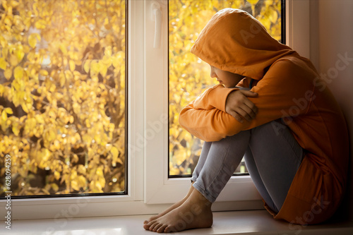 Depressed Teenager Girl by Autumn Window. Unhappy Sad Stressed Lonely Upset Disappointed Teen Childat Home. Teenage Difficulties Frustration. © Maryana