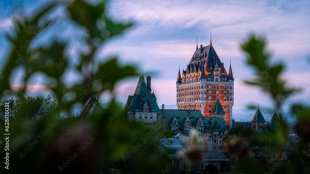 Naklejka premium Nice view over the famous Chateau Frontenac hotel in the background, under the dusk light, blurred foreground. Old Quebec city, Canada