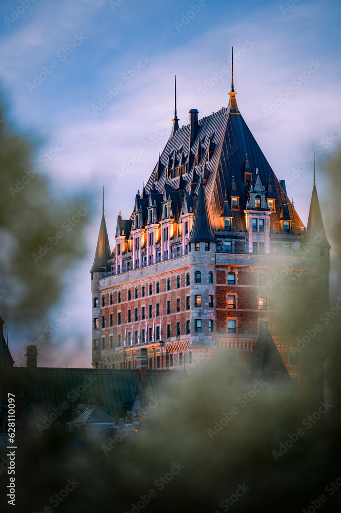 Fototapeta premium Nice view over the famous Chateau Frontenac hotel in the background, under the dusk light, blurred foreground. Old Quebec city, Canada