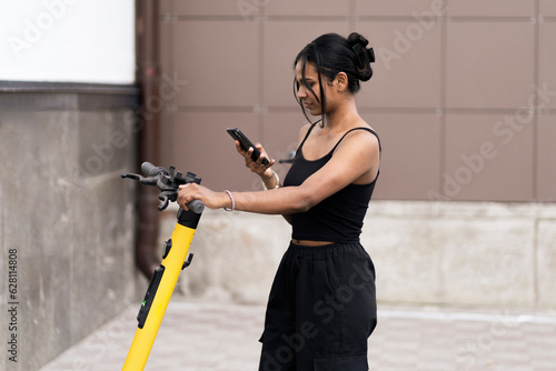 Wallpaper Mural young black woman taking a scooter for a rent in the city, eco friendly vehicle Torontodigital.ca
