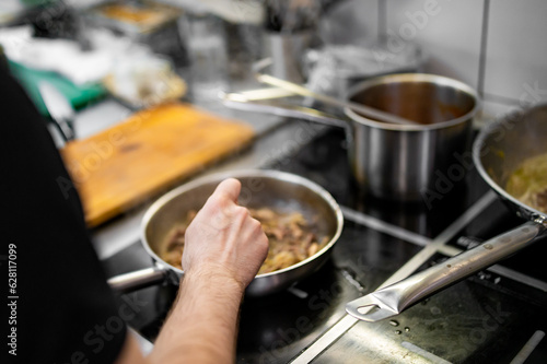 Chef cook hand cooking food at the restaurant kitchen