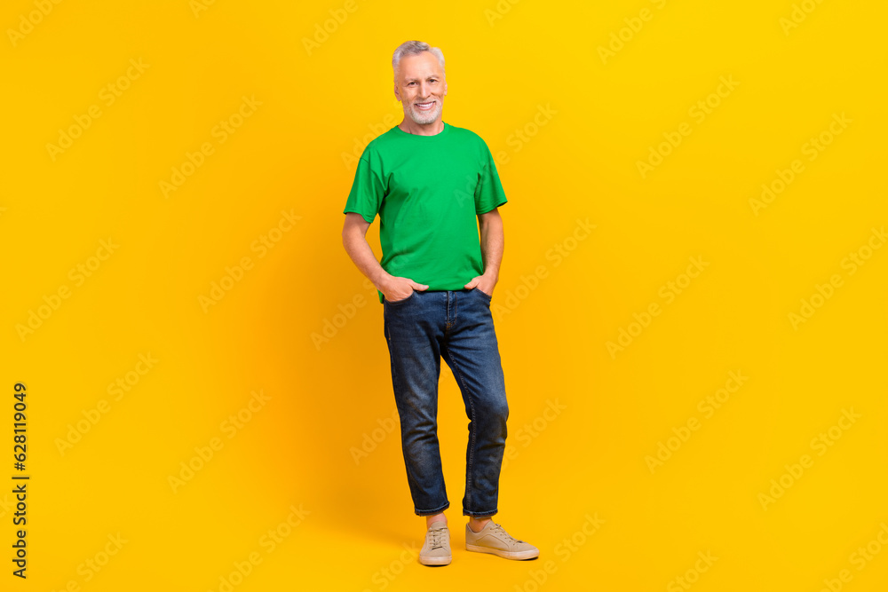 Full length photo of friendly satisfied glad aged person put hands pockets posing isolated on vivid yellow color background Full length photo of friendly satisfied glad aged person put hands pockets posing isolated on vivid yellow color background
